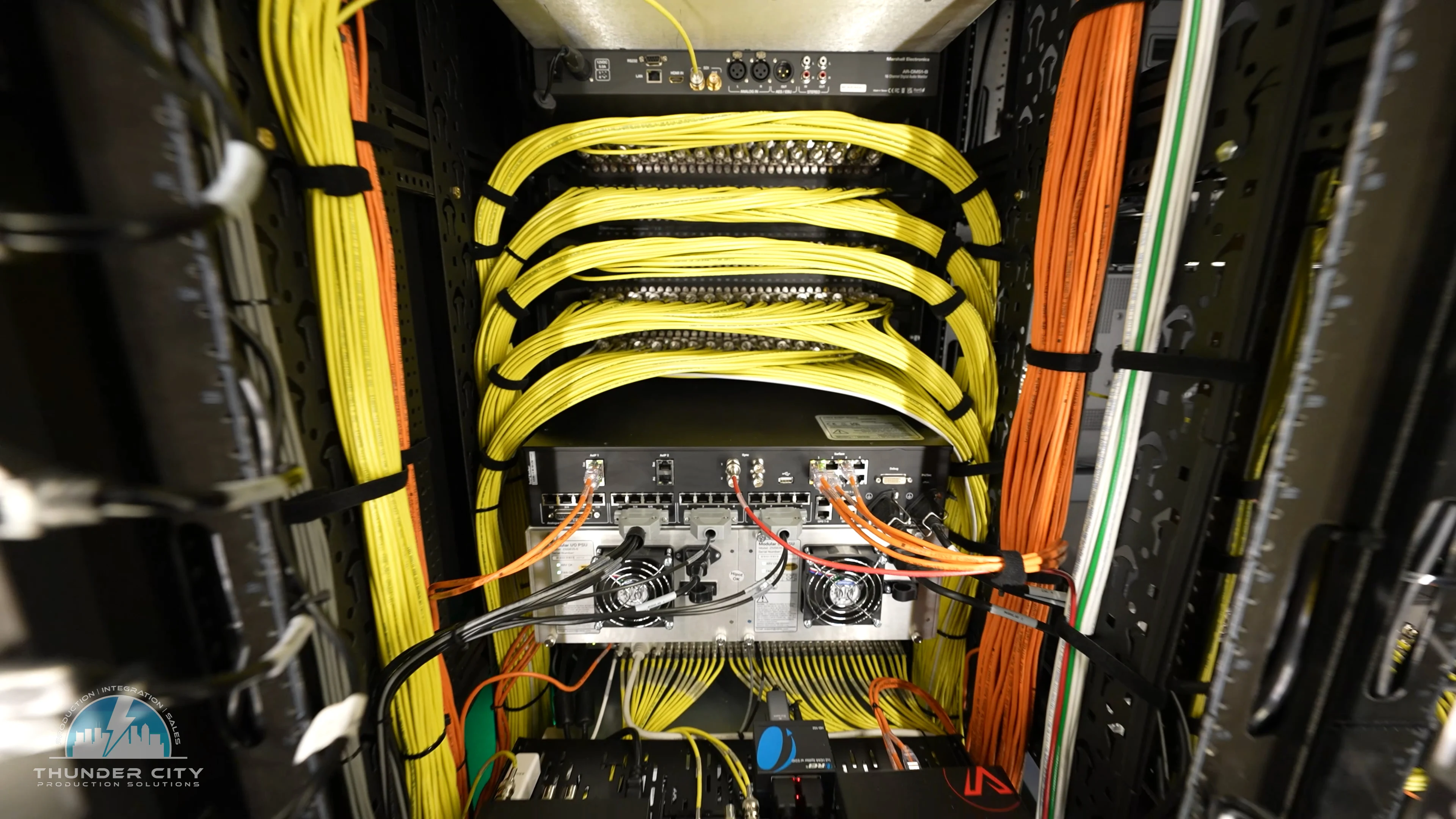 Rear equipment rack with organized yellow and orange cabling